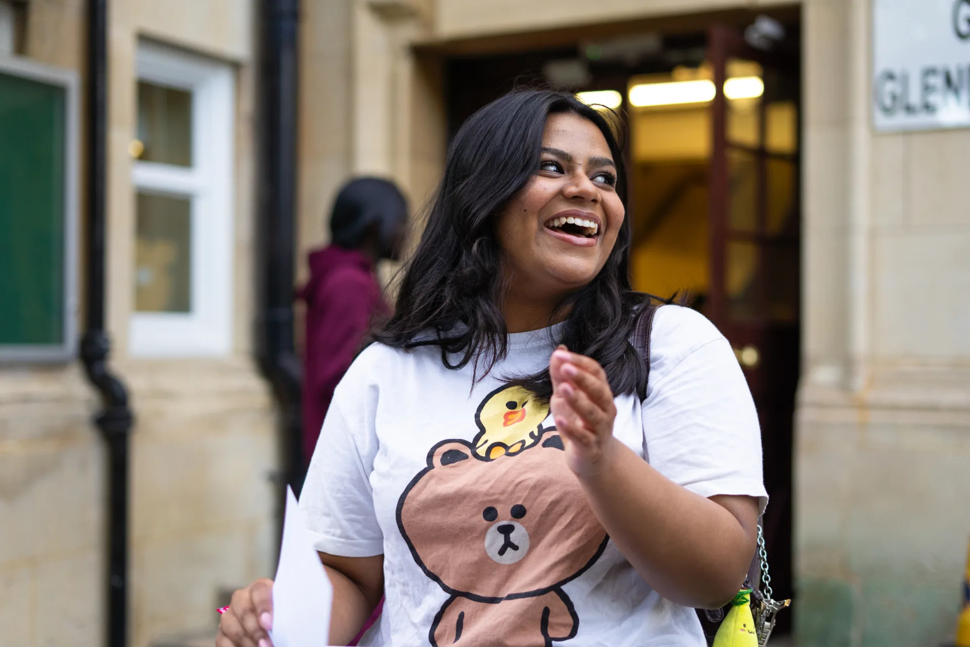 Smiling student with The Access Project standing outside her school, having received her results on A level results day.